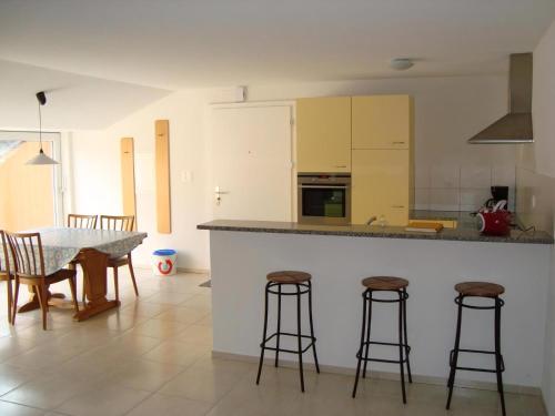 a kitchen with a table and some bar stools at Rehalp Osten in Bischofszell