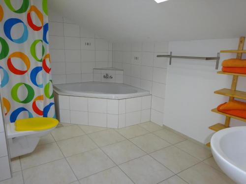 a bathroom with a tub and a toilet and a sink at Rehalp Osten in Bischofszell