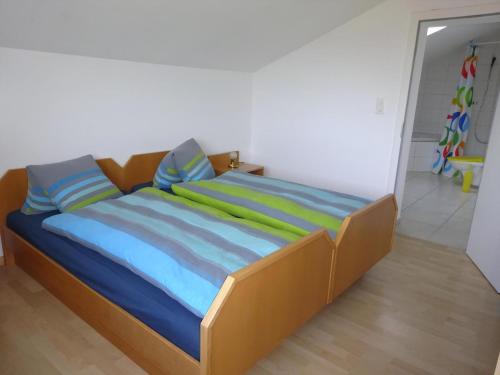 a bed with colorful sheets and pillows in a room at Rehalp Osten in Bischofszell