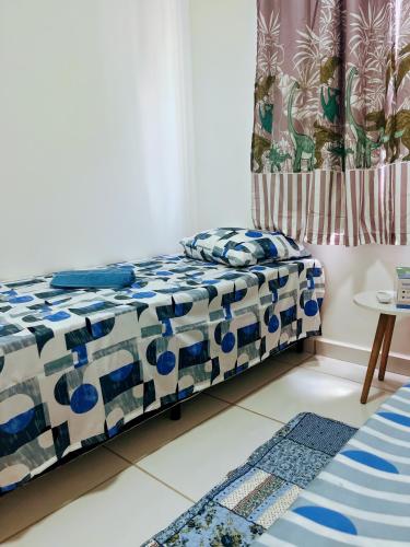 a bedroom with a bed with blue and white sheets at Impera House Ar nos dois quartos in Imperatriz