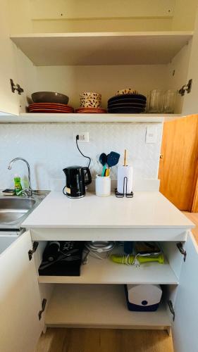 a kitchen shelf with a sink and some dishes at Cabaña Papudo in Papudo