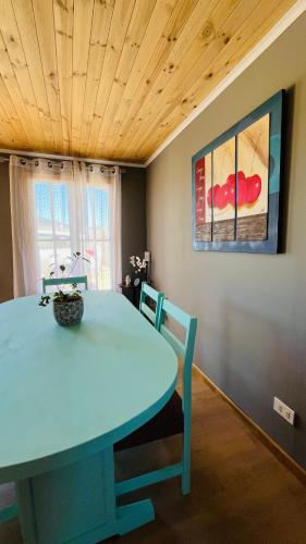 a dining room with a blue table and chairs at Cabaña Papudo in Papudo