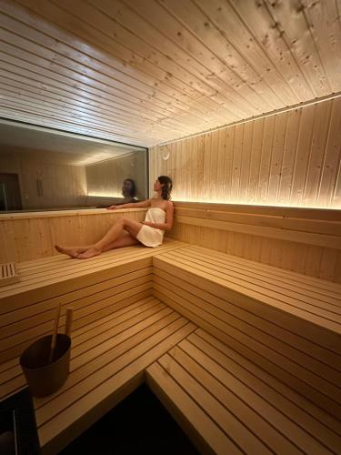 a woman sitting in the inside of a sauna at Landhuis Hotel de Hilkensberg in Broekhuizen