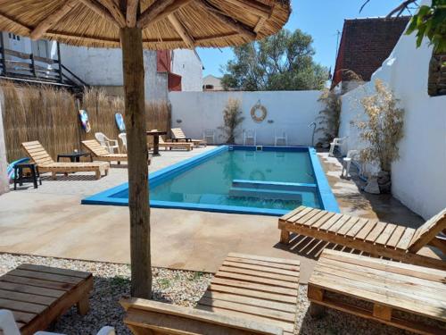 a swimming pool with chairs and an umbrella at Costa Clara Hotel in Santa Clara del Mar
