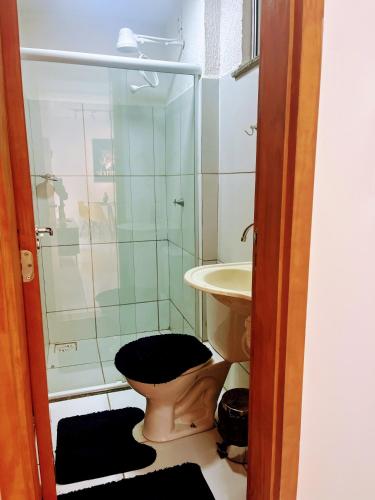 a bathroom with a shower and a toilet and a sink at Impera House Ar nos dois quartos in Imperatriz