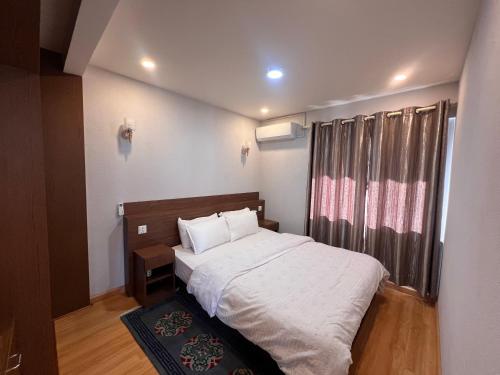 a small bedroom with a bed and a window at Avocado Accommodations in Khadkagaon