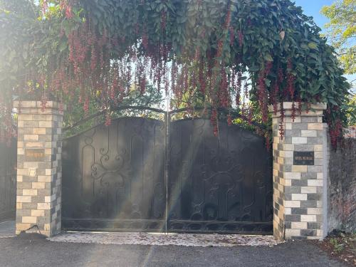 a black gate with plants on top of it at Avocado Accommodations in Khadkagaon