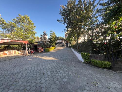 a cobblestone street with trees on the side at Avocado Accommodations in Khadkagaon