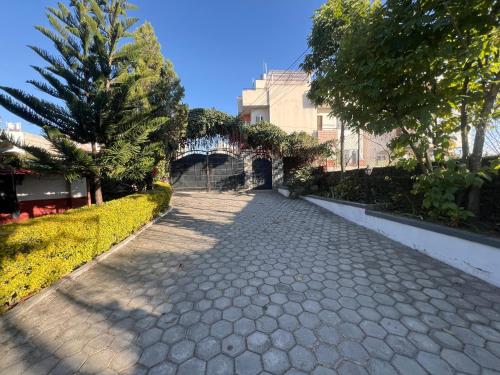 a cobblestone street with a bridge and trees at Avocado Accommodations in Khadkagaon