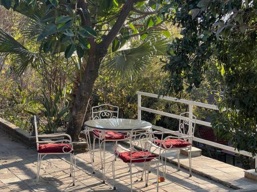 a table and two chairs and a table and a tree at Avocado Accommodations in Khadkagaon