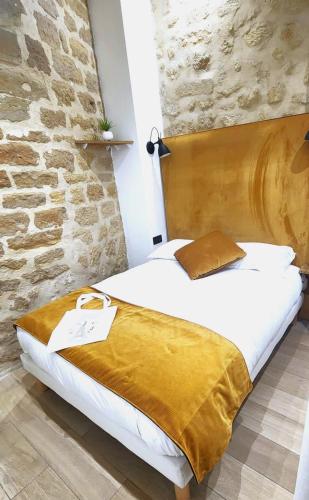 un lit dans une chambre avec un mur en pierre dans l'établissement Home in Paris Chatelet great apt for 6px, à Paris
