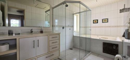 Un baño con ducha, lavabo y bañera. en Pousada Casa Campeche - Floripa, en Florianópolis