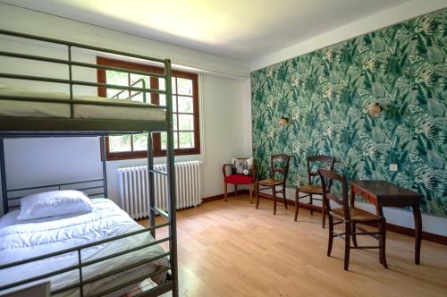 - une chambre avec des lits superposés, un bureau et des chaises dans l'établissement Maison familiale tradition landaise, à Andernos-les-Bains