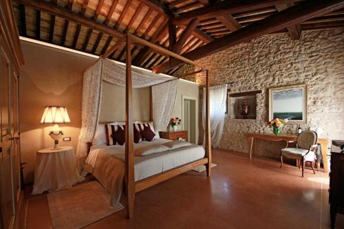 een slaapkamer met een hemelbed in een bakstenen muur bij Villa Della Torre in Fumane