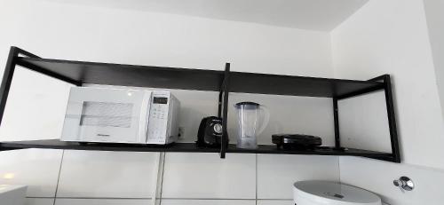 a black shelf with a microwave and a blender on it at Max Derby - Studios no Centro do Recife por Yolo in Recife
