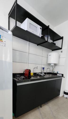 a kitchen with a sink and a microwave at Max Derby - Studios no Centro do Recife por Yolo in Recife