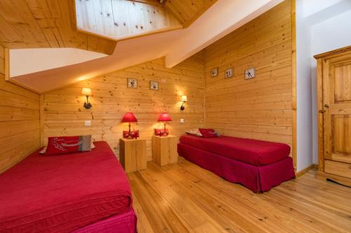 due letti in una stanza con pareti in legno di Etoile des neiges a Ventron