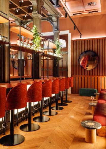 a bar with orange stools in a restaurant at Locke de Santa Joana in Lisbon