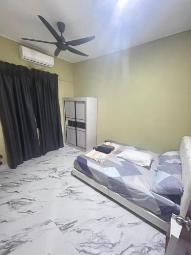 a bedroom with a bed and a ceiling fan at Homestay Taman Hidayah Chawas in Tanah Merah