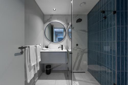 a bathroom with a sink and a mirror and a shower at Quarters 405 in Cape Town