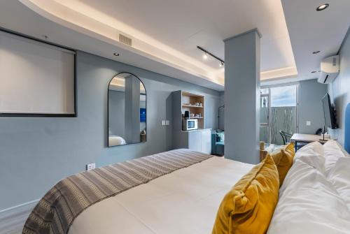 a bedroom with a large bed and blue walls at Quarters 405 in Cape Town