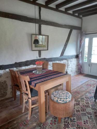 une salle à manger avec une table et des chaises en bois dans l'établissement La Chaumière Enchantée, à Saint-Christophe-sur-Condé