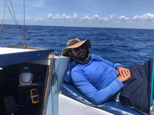 a man sitting on a boat in the ocean at Veleiro Ventão - Passeio de mini iate in Marau