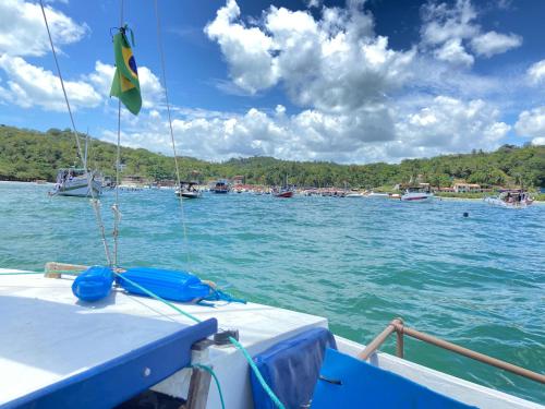 a boat in the water with a flag on it at Veleiro Ventão - Passeio de mini iate in Marau