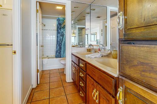 a bathroom with a sink and a toilet and a mirror at Ocean Vista #1101 in South Padre Island