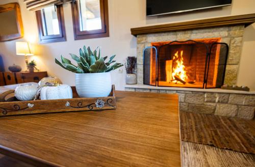 a fireplace in a living room with a wooden table with a table sidx sidx sidx at Alexi's House in Kalavrita