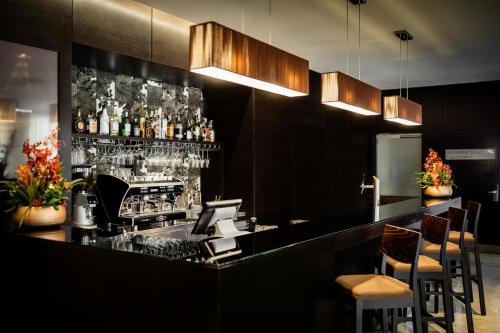 a bar in a restaurant with a counter and chairs at Occidental Praha Five in Prague