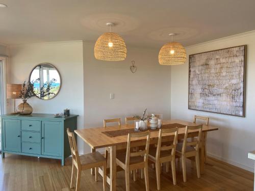 a dining room with a wooden table and chairs at Samphire Stays at Foul Bay in Marion Bay