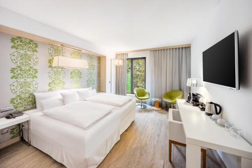 a hotel room with a white bed and a desk at Occidental Praha Five in Prague