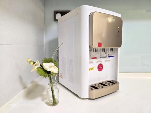 a microwave oven on a counter with a vase of flowers at Loft Suite Central City 2BR JB CIQ 7Pax in Johor Bahru