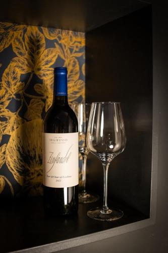 a bottle of wine sitting next to a wine glass at Studio Kittel Guest Room with Private Bathroom in Bruges