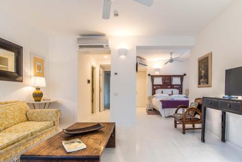 a living room with a couch and a bedroom at Il San Francesco Charming Hotel in Sabaudia