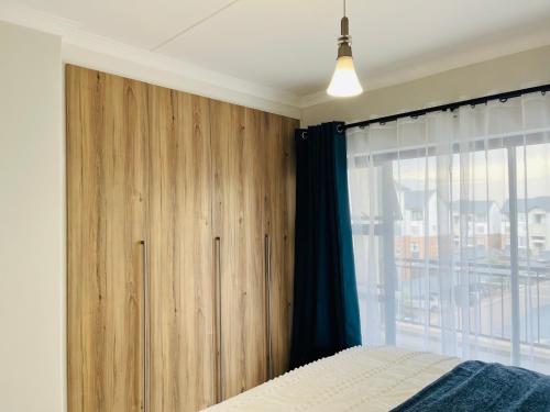 プレトリアにあるThe Blydeのベッドルーム1室(窓際に木製キャビネット付)