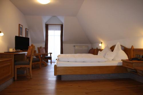 a bedroom with a bed and a desk and a television at Die Krone in Staufen im Breisgau