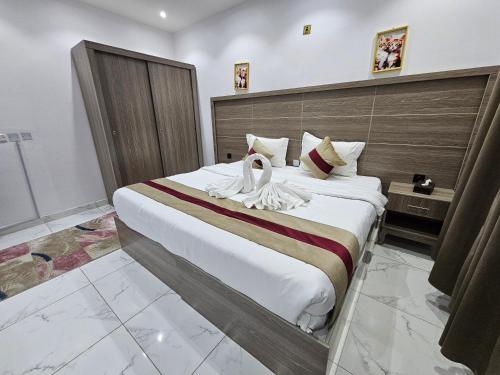 a bedroom with a large bed with two swans on it at Ajyal Al Madina Hotel 2 in Sīdī Ḩamzah
