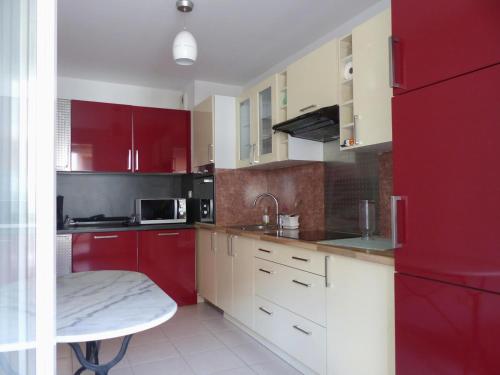 Il comprend une cuisine équipée de placards rouges et d'un réfrigérateur rouge. dans l'établissement LE PLAYA Fréjus plage Saint-Raphael, à Fréjus
