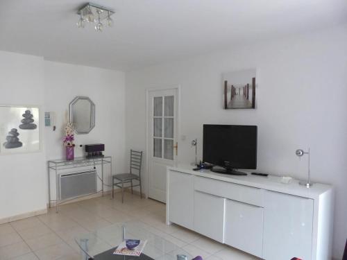 un salon avec une télévision sur un mur blanc dans l'établissement LE PLAYA Fréjus plage Saint-Raphael, à Fréjus