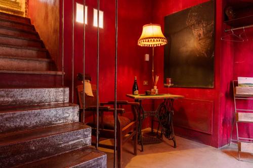 a red room with a table and a lamp at Casa Baladin camere di Charme e Agronidi dell'Open Garden in Piozzo