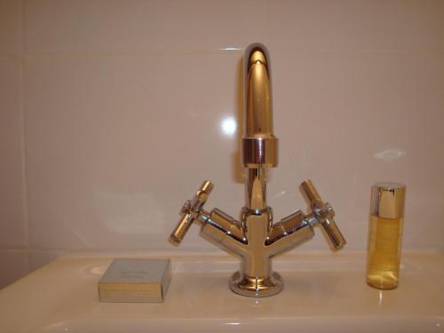 a sink with a brass faucet and a glass at Willa Viktoria in Inowrocław