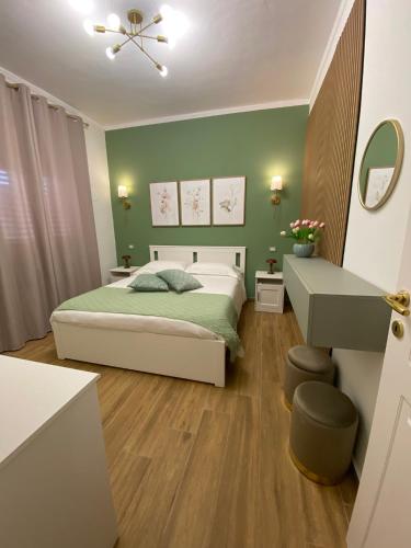 a green bedroom with a bed and a sink at Cicero’s - Intero alloggio in Castelbuono