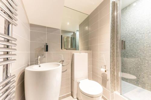 a white bathroom with a toilet and a sink at Home in Paris Marais Elegant Flat in Old Paris in Paris