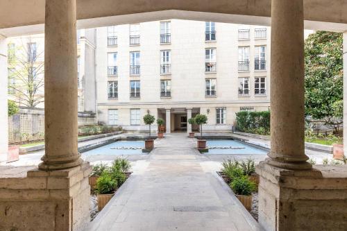 - une vue extérieure sur un bâtiment avec une piscine dans l'établissement Home in Paris Marais Elegant Flat in Old Paris, à Paris