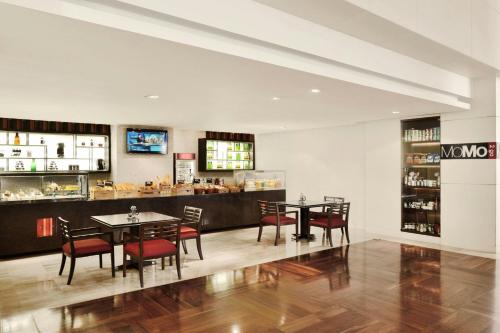 a restaurant with tables and chairs and a bar at Courtyard by Marriott Pune Hinjewadi in Pune