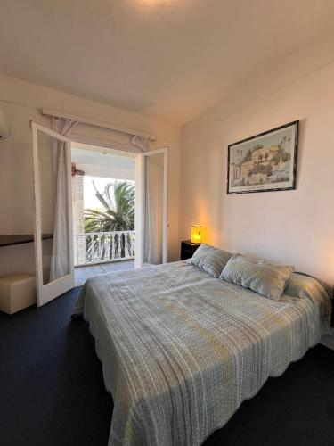 a bedroom with a bed and a large window at Hotel Cabo Santa Maria in La Paloma