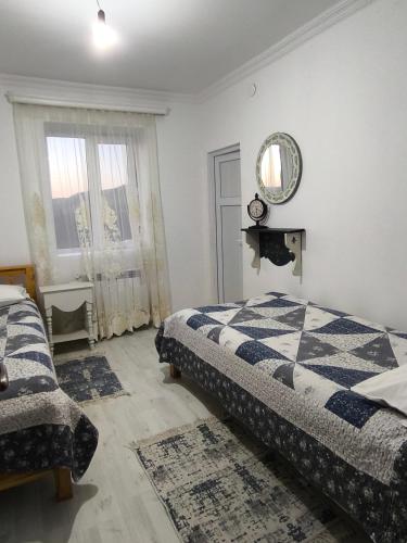 a bedroom with two beds and a mirror on the wall at Green Lake Vashlovani in Kasristsqali