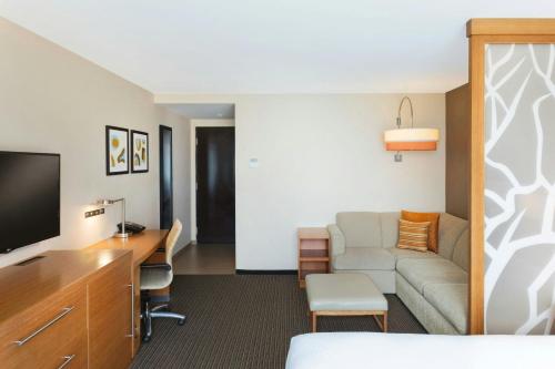 a hotel room with a couch and a desk at Courtyard by Marriott La Paz Baja California Sur in La Paz